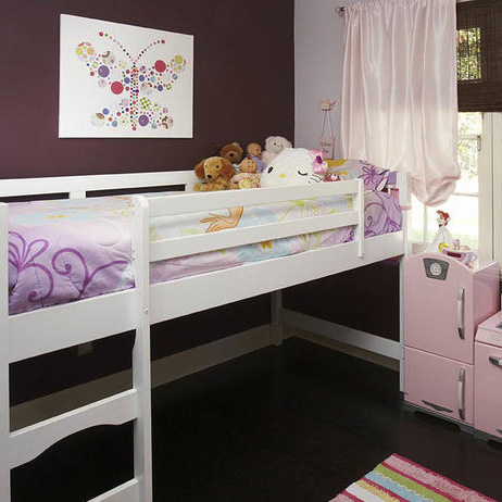 Pink bedroom with toy kitchen area, white bunk bed frame with stuffed animals and hello kitty, and striped rug on a hardwood floor in this girls bedroom.